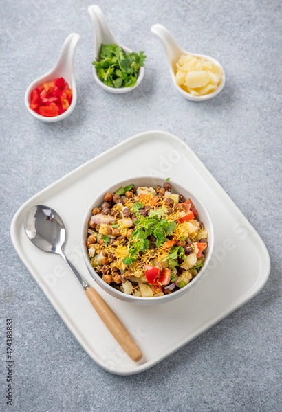 Fototapeta black gram or kala chana chaat with boiled potato, onion, tomato with a dash of lemon juice served on a white bowl