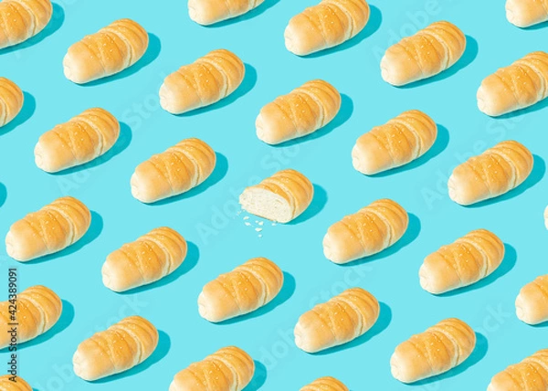 Obraz Real life bakery pattern made of fresh homemade cryspy bread on pastel blue background. Sliced pastry. Bright light, sharp shadows.