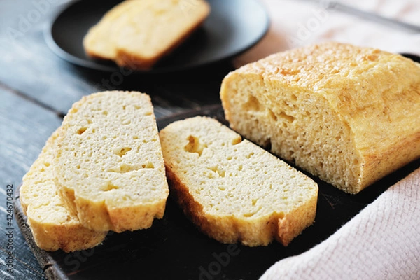 Fototapeta homemade keto bread on grey wooden table. slices of fresh baked low carb bread. LCHF diet concept. flourless baking