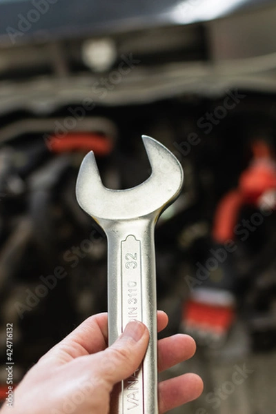 Obraz hand of a caucasian man holding a wrench with decision, prepared to fix a car