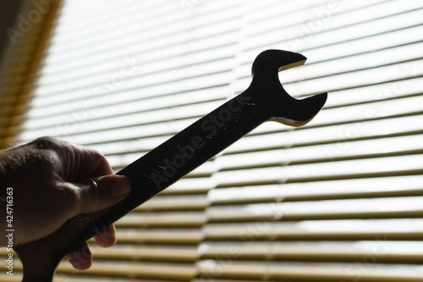 Obraz Hand holding a wrench with backlit