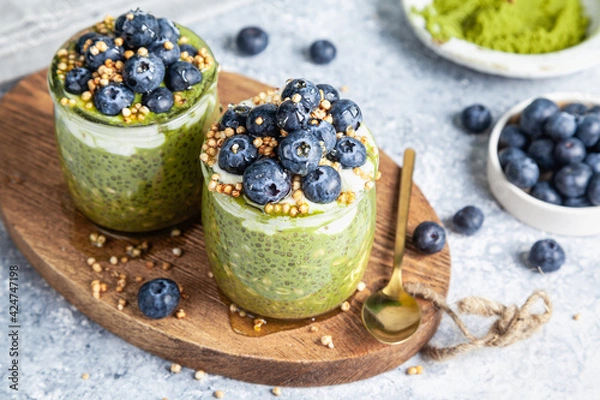 Fototapeta Overnight matcha chia oats are topped with yogurt and blueberries.