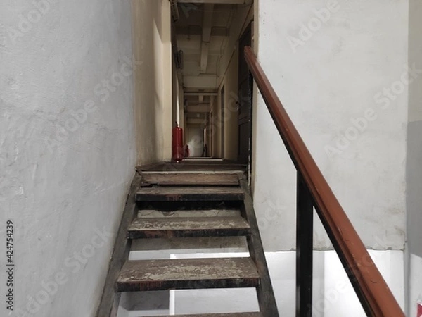 Fototapeta Narrow fire passage with a ladder and fire extinguishers on the floor