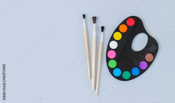Obraz Art palette with paint and brushes top view on gray background