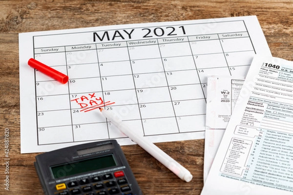 Fototapeta Internal Revenue Service (IRS) has extended the deadline for filing US federal income tax until May 17 2021. Concept image showing a calendar page marking the new tax day for 2021.
