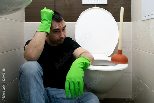 Fototapeta Drain Problems, blockage plumbing toilet unclog plunger force cup man sit floor