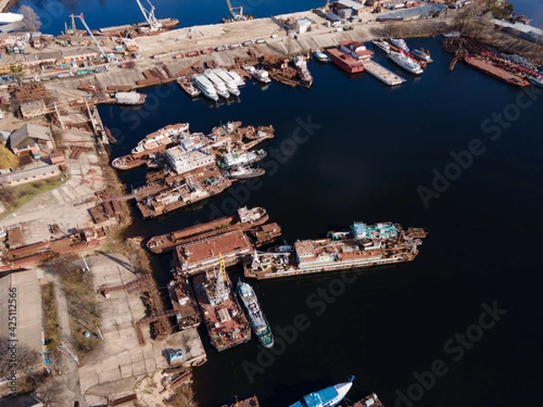Fototapeta Aerial view of moored old barges and ships in river port