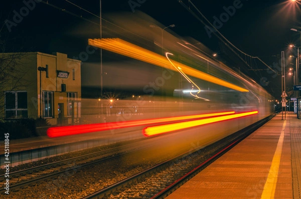 Obraz The lights of a running train at a train station.