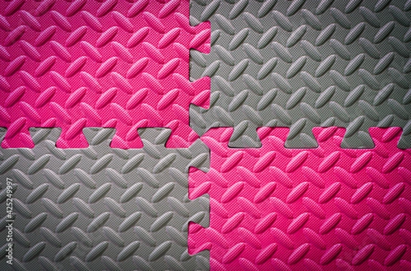 Fototapeta Colorful Jigsaw Foam flooring tiles or mat in grey and pink in metal floor look for anti slip and safety , vignette effect for background texture