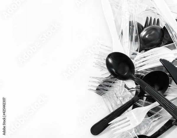 Fototapeta Pile of clean plastic takeaway cutlery on table (spoon, fork, knife). Reusable or recycle utensil in minimal, contrast and monotone concept (black, white, clear color collection) with negative space.