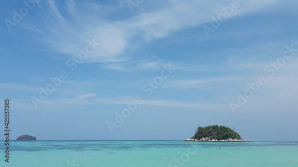 Obraz Beautiful white clouds on blue sky over calm sea with sunlight reflection.Sunny sky and calm blue ocean. Vibrant sea with clouds on horizon.