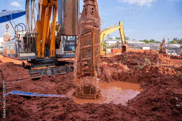 Fototapeta Earth drilling machine for drilling piles, Earth drilling machine or hydraulic boring machine into a construction site