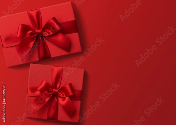 Fototapeta Two red gift boxes on red background flat lay, present box top view	