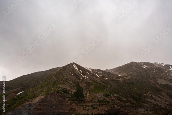 Fototapeta Panta de Sallente, in the Vall Fosca in the Pyrenees. On a day of early spring, cloudy and rainy. The swamp is quite empty, waiting to be filled with the melting of the mountains next door.