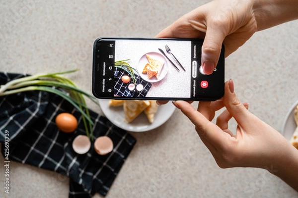 Fototapeta making photo of a plate of rolls with cheese and herbs