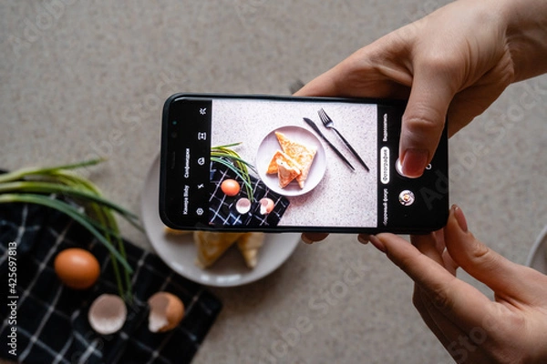 Fototapeta food blogger making photo of a plate of rolls with cheese and herbs
