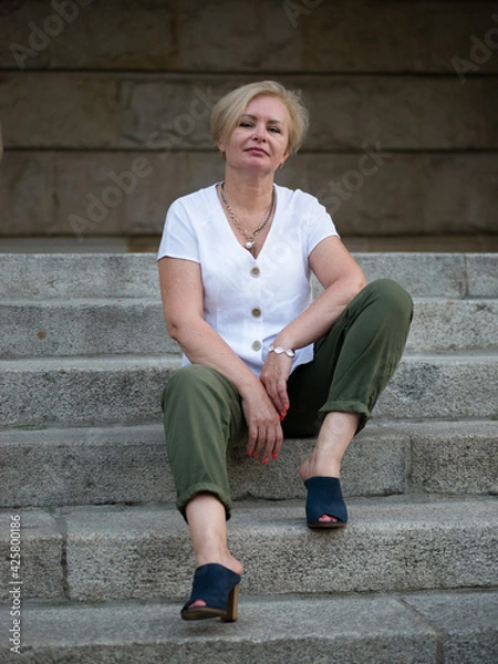 Obraz Old and stylish woman on a summer walk in beautiful city.