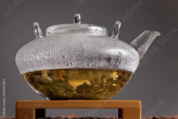 Obraz Glass teapot with tea leaves and water