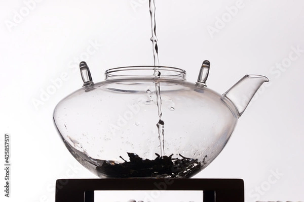 Obraz Silhouette of water pouring in clear glass teapot on white background