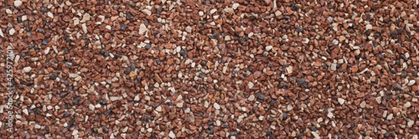 Fototapeta Texture of small stones, rocky abstract background, grainy surface, gravel pattern, red pebbles. Decorative design, brown colored. Grunge wall backdrop.