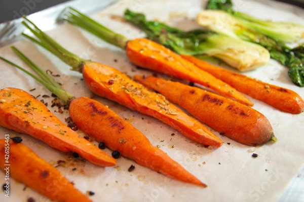 Fototapeta Roasted vegetables above view. Carrots and Chinese cabbage bok choy. Selective focus.