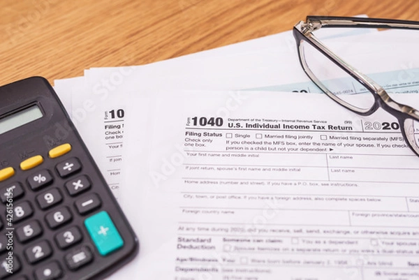 Fototapeta tax forms 1040 with calculator and glasses