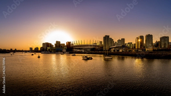 Fototapeta Sun setting over the Vancouver Skyline at the North Shore of False Creek, British Columbia, Canada