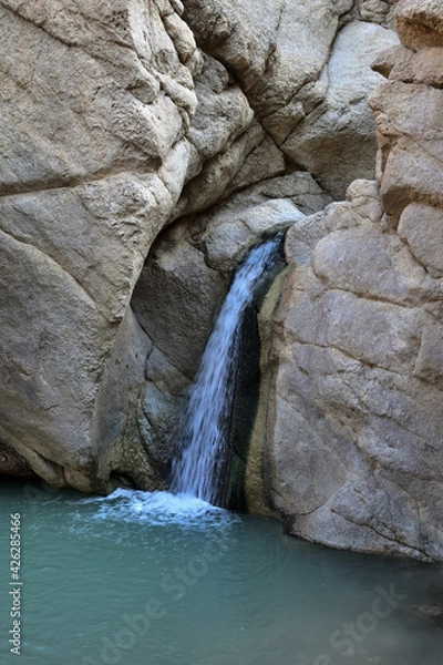 Fototapeta waterfall in the mountain gorge of the desert Atlas Mountains