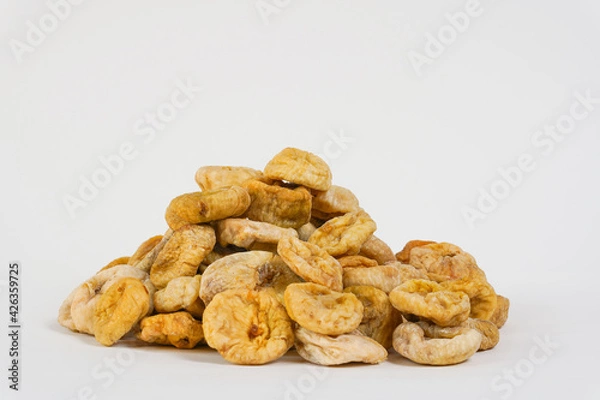 Obraz Natural dried figs. Sun dried figs on white background. Studio photo. Sun dried fruits. Copy space.  Health, organic concept.