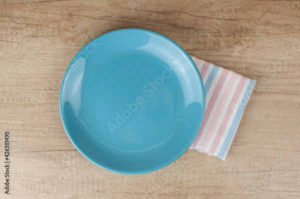 Obraz Empty plate and towel over wooden table background. View from above with copy space