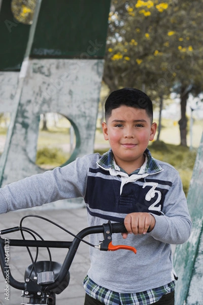 Obraz Boy walking with his bicycle.