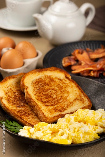 Fototapeta Breakfast. Scrambled egg with toast and bacon.