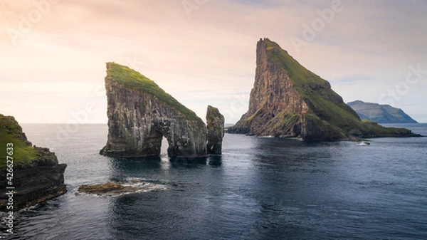 Fototapeta Drangarnier rock formations and Tindholmur island in sunset with clouds on Vagar, Faroe Islands.