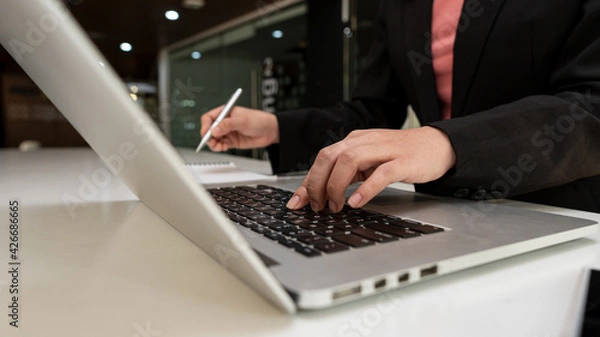 Fototapeta An accountant works with a laptop in his office.
