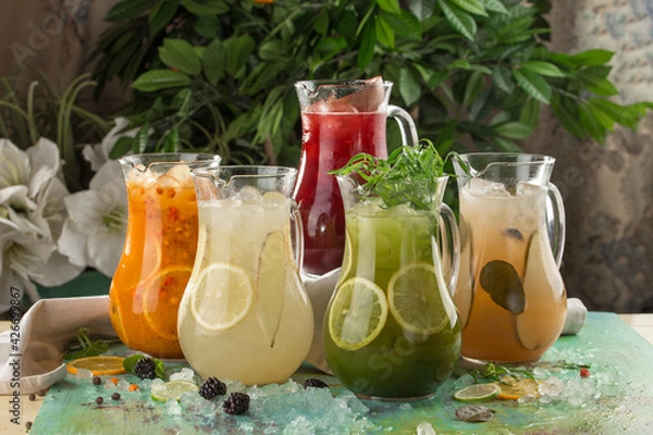 Fototapeta five pitcher with colorful lemonade on the table