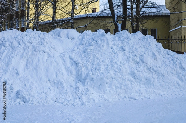 Obraz Large piles of snow on the side of the road for cars. High drifts after a snowfall or blizzard