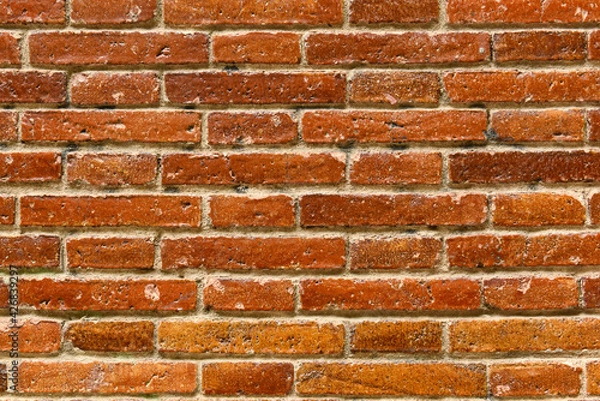 Fototapeta Old red brick background with fired enamel. Wall made of ceramic transom or crossbar bricks. Weathered Stained Old Brick Wall