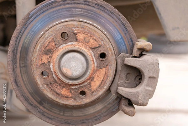 Fototapeta Heavily worn brake disc. Car brake disc after removing the wheel. A rusty disk that needs to be replaced.