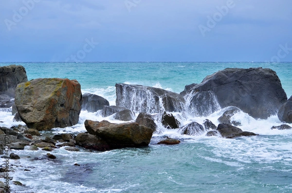 Obraz waves crash on stones.  blue sea