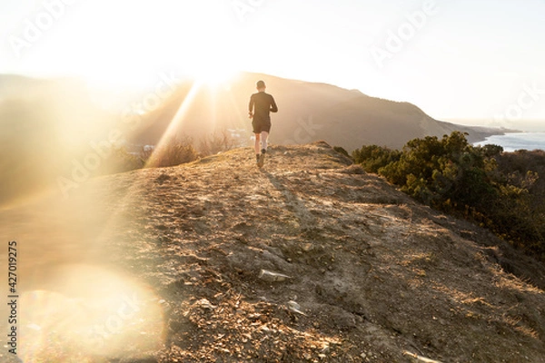 Fototapeta Running man on mountain and sunrize background