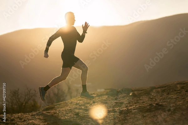 Fototapeta Running man silhouette on the mountain background