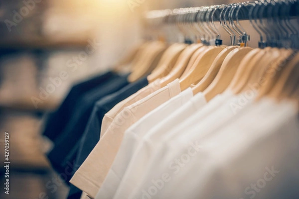 Obraz T-shirts on hangers. Shopping in store. Clothes on hangers in shop for sale