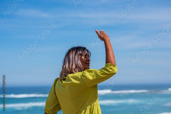 Fototapeta Woman shielding her face from the sun