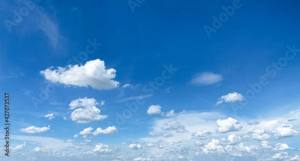 Fototapeta Blue sky background with white clouds in large, small chunks, and has a wide area to sleep on messages or advertisements.