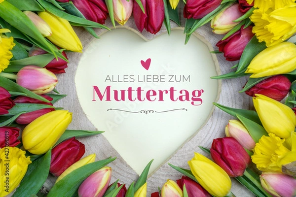 Fototapeta Alles liebe zum Muttertag. Herz aus Holz umgeben von Blumen (Tulpen) mit Glückwunsch.