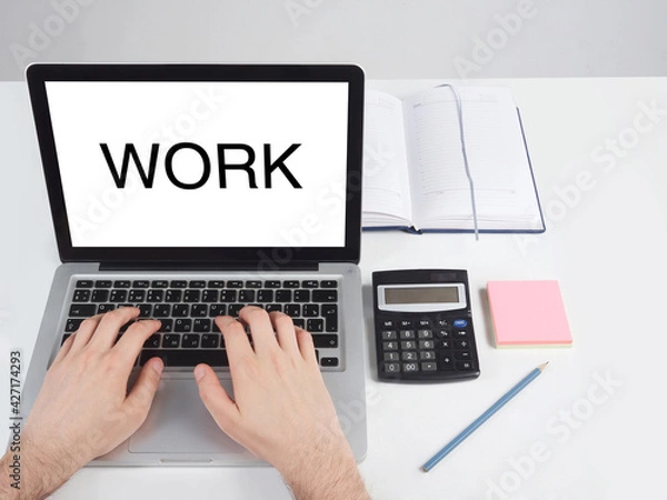 Fototapeta a man sitting at a desk and working at a computer with his hands,  Office desktop on a white background.
