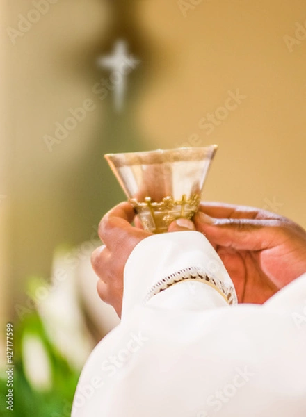 Obraz hands of the priest raise the blood of Christ