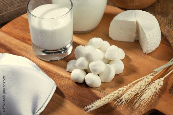 Obraz Mozzarella cheese  and milk on wooden stand and spikelets of wheat.Concept for Shavuot holiday.