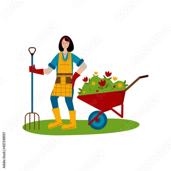 Obraz A young girl with a pitchfork stands next to a wheelbarrow with seedlings of flowers. A hobby is gardening.
