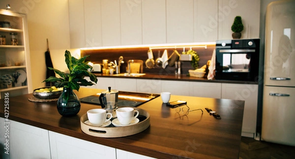 Fototapeta Modern and technology kitchen in new luxury home with wooden island, hardwood floors, white wood cabinets, and stainless steel appliances. Design and interiors concept